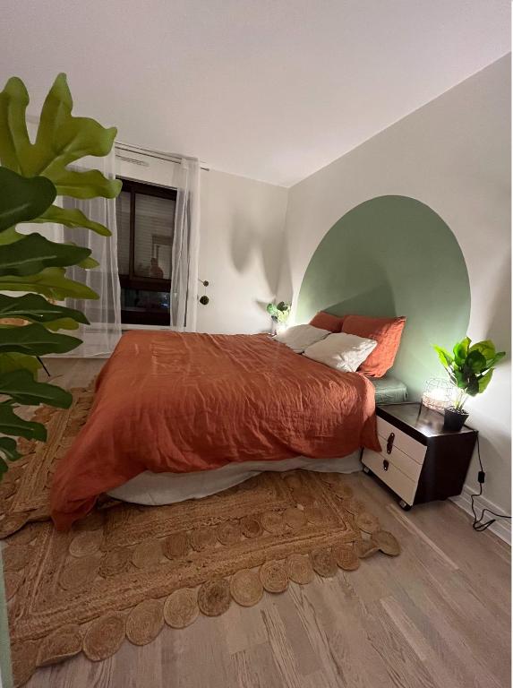 une chambre avec un grand lit avec une couverture orange dans l'établissement Parisian cocoon- Luxembourg garden- Independant, à Paris