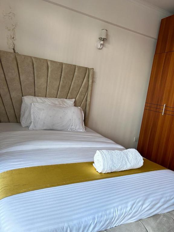 Una cama en una habitación con una almohada blanca. en mopearlz skyhorse apartment, en Nairobi