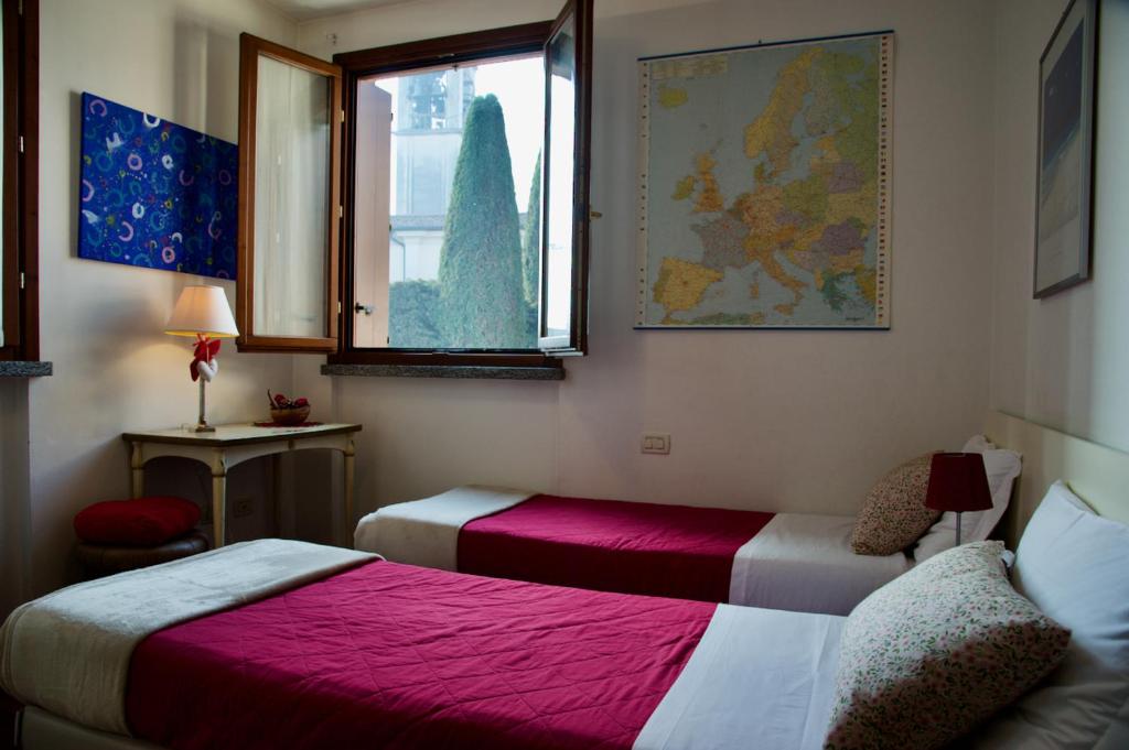 een slaapkamer met 2 bedden en een raam bij Casa Vacanze La Torre in Orio al Serio
