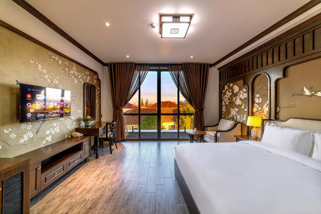 une chambre d'hôtel avec un lit et une télévision dans l'établissement Le House DaLat, à Đà Lạt