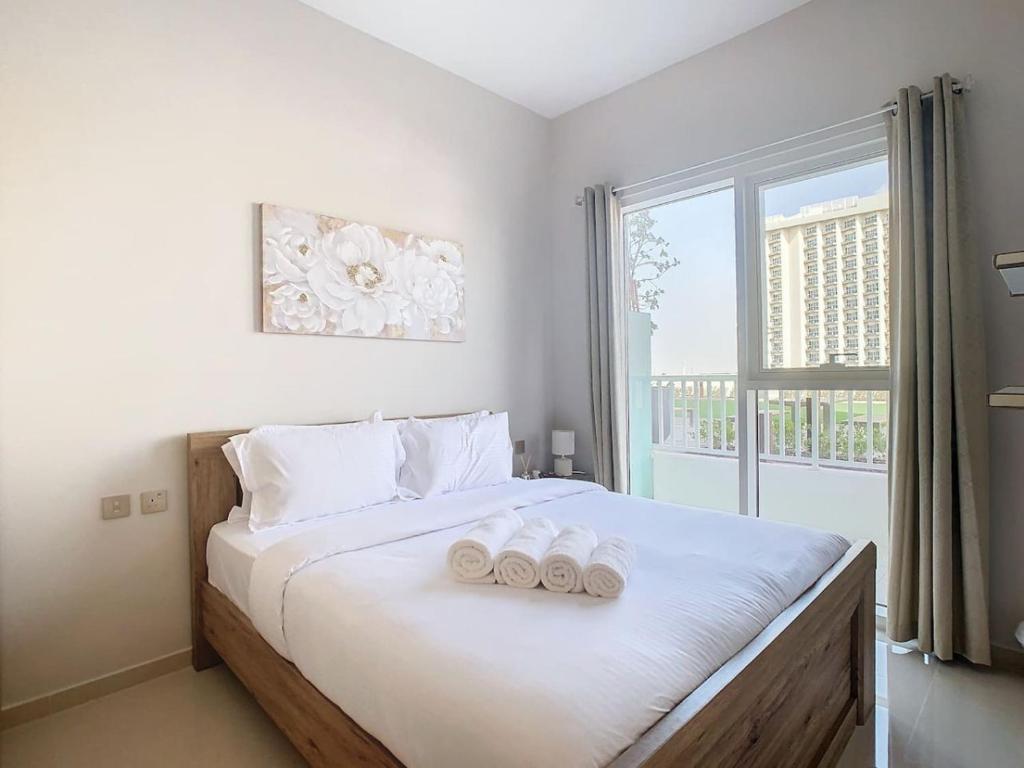 1 dormitorio con 1 cama con 2 toallas en Key View - Navitas Tower A, en ‘Ūd al Bayḑāʼ