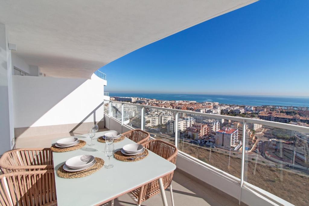 einen Balkon mit einem Tisch und Stühlen sowie Stadtblick in der Unterkunft Global Properties, Moderno apartamento de dos terrazas con increibles vistas al mar in Canet d'en Berenguer