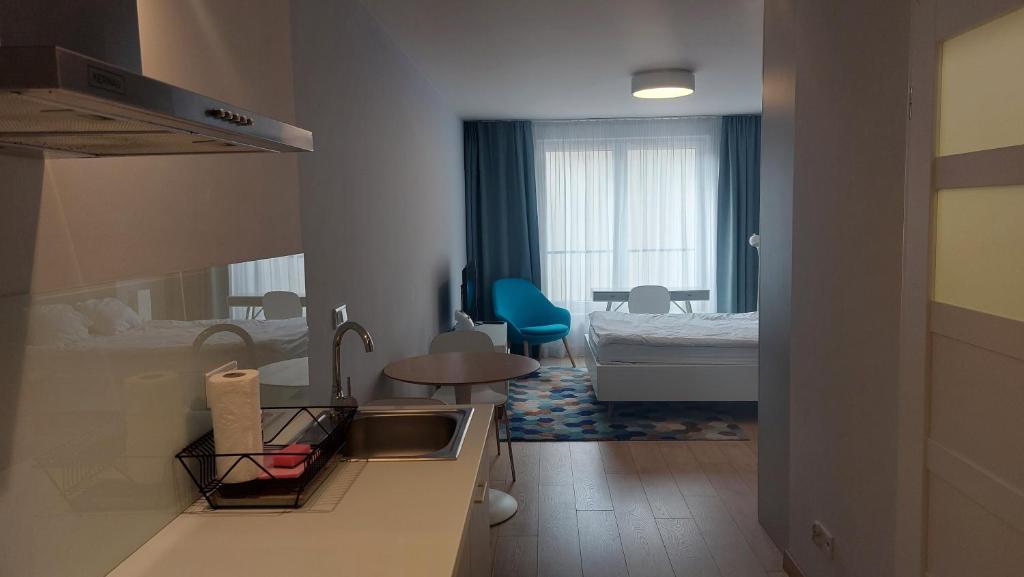 uma casa de banho com um lavatório e um quarto com uma cama em Kazimierz Center Apartments Halicka em Cracóvia