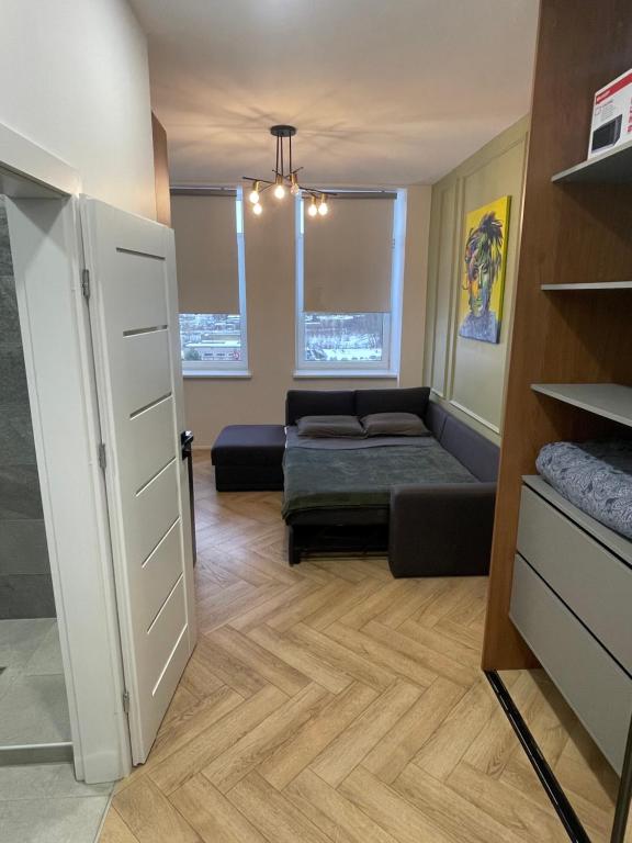 um quarto com uma cama e um sofá num quarto em Airport Apartment 14 Self Check-In Free parking em Vilnius