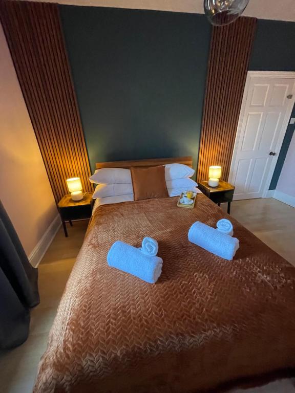 a bedroom with a bed with two blue towels on it at Spacious Seaside House in Cleethorpes