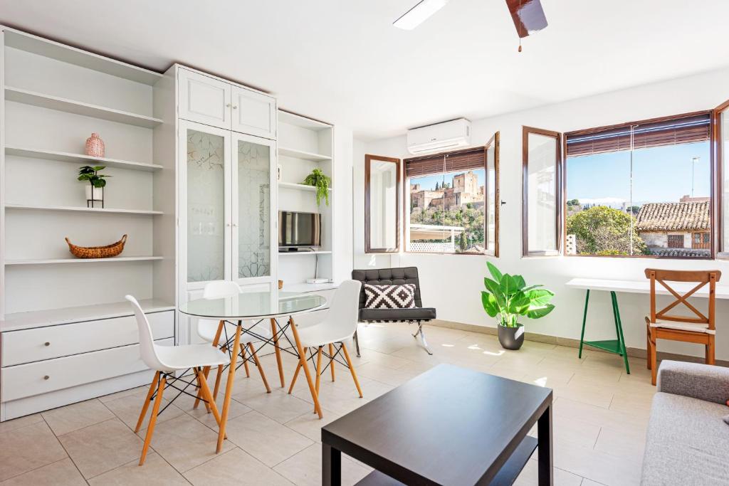 a kitchen and living room with a table and chairs at Apartamentos Bravo by A3 Rentals in Granada