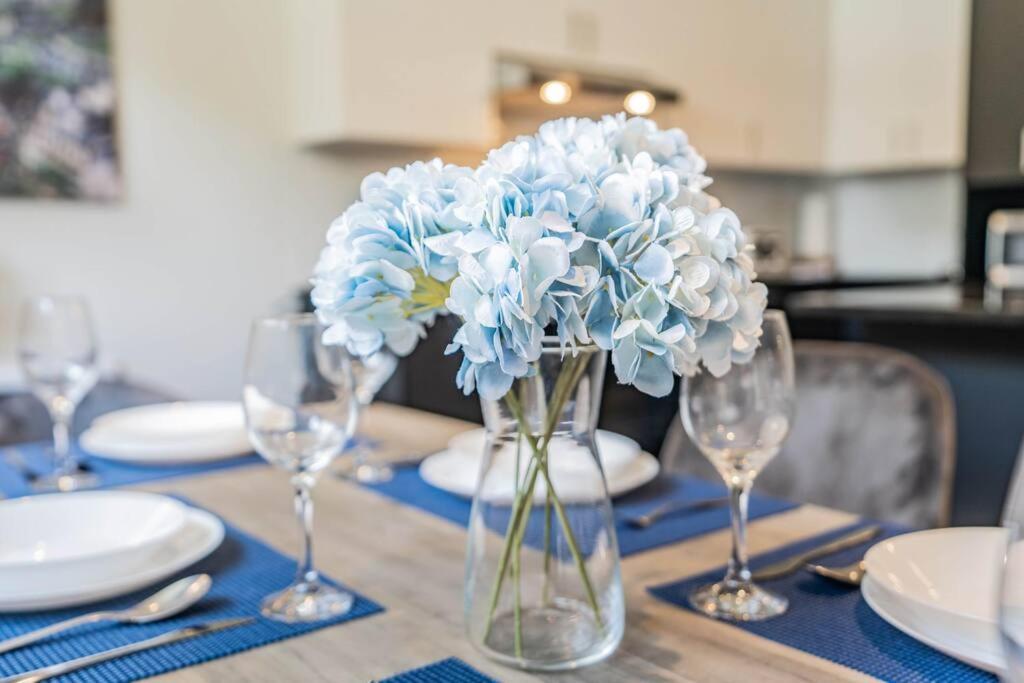 a vase filled with blue flowers sitting on a table at Free Parking - Best Travel by Zen Living in Longueuil