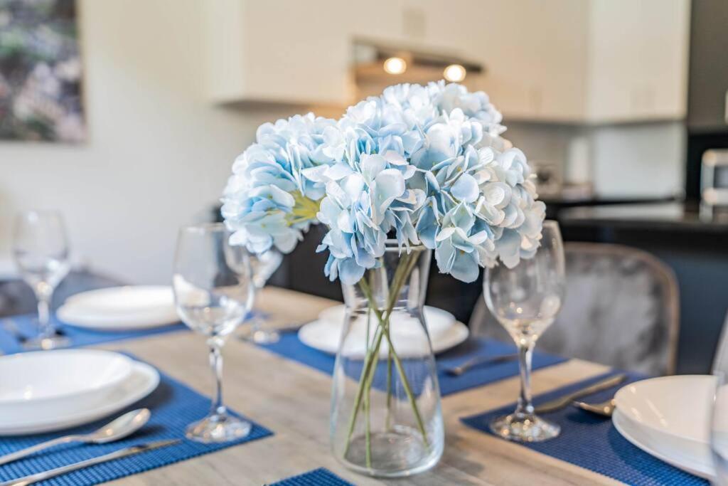 wazon pełen niebieskich kwiatów siedzących na stole w obiekcie Free Parking - Best Travel by Zen Living w mieście Longueuil