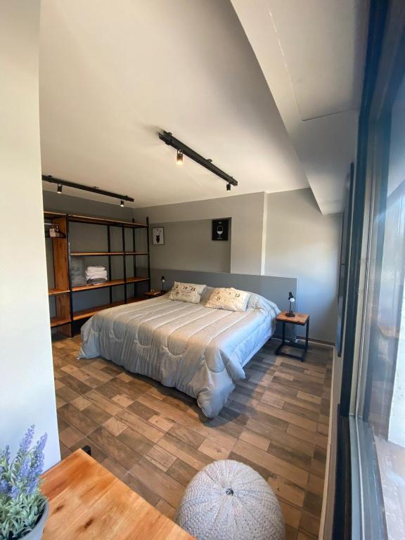 a bedroom with a bed and a wooden floor at Departamento Campana Centro in Campana