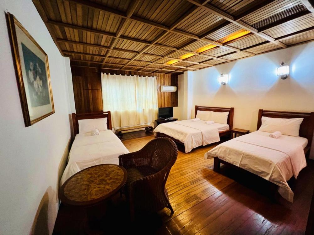 a room with two beds and a table in it at i villa inn in Kuala Lumpur