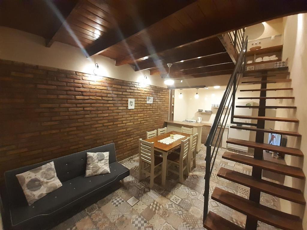 Pokój z kanapą, stołem i ceglaną ścianą w obiekcie Duplex Mi Lar w mieście Termas de Río Hondo