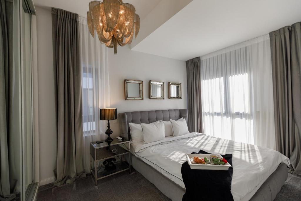 a bedroom with a bed with a tray of food on it at Luxury and cozy apartment with a beautiful view in Bucharest