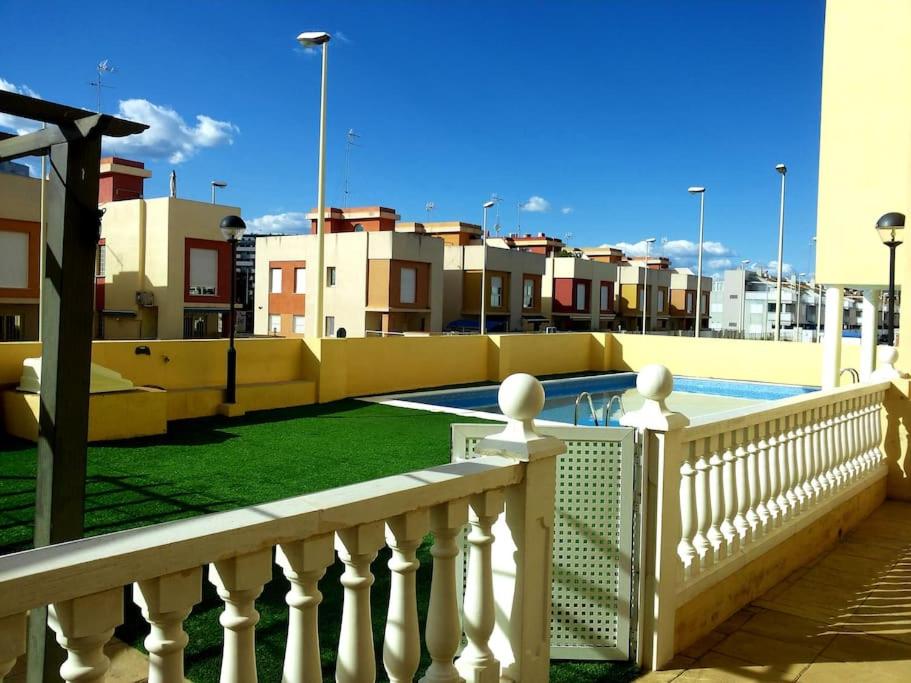 a balcony with a fence and a swimming pool at Apartamento con piscina a pocos metros de la playa in Moncófar