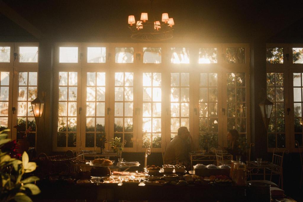 a dining room with a large window with people sitting at a table at Villa Alto Boutique Hotel in Ponta do Sol