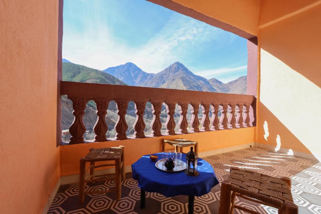 Tamatert Guest House في إمليل: غرفة مع طاولة وإطلالة على الجبال