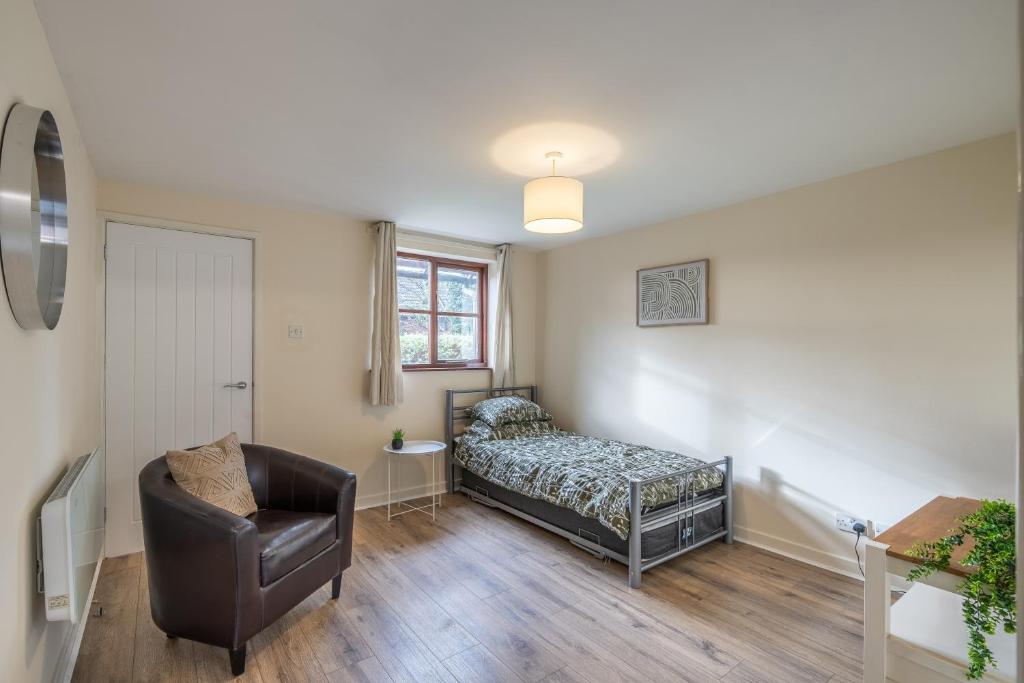 1 dormitorio con 1 cama y 1 silla en Modern studio flat in Wellington, Telford, en Wellington