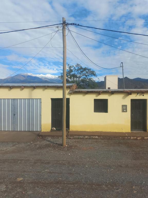 a yellow building with a pole in front of it at Casa de familia in Cachí