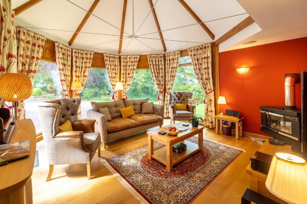 een woonkamer met een bank en een tafel bij Heads Nook Hall Cottage in Carlisle