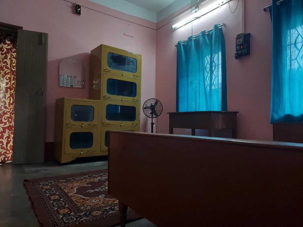 a room with blue curtains and a room with a table at Roadji Stays 001, Madhuri Villa in Agartala