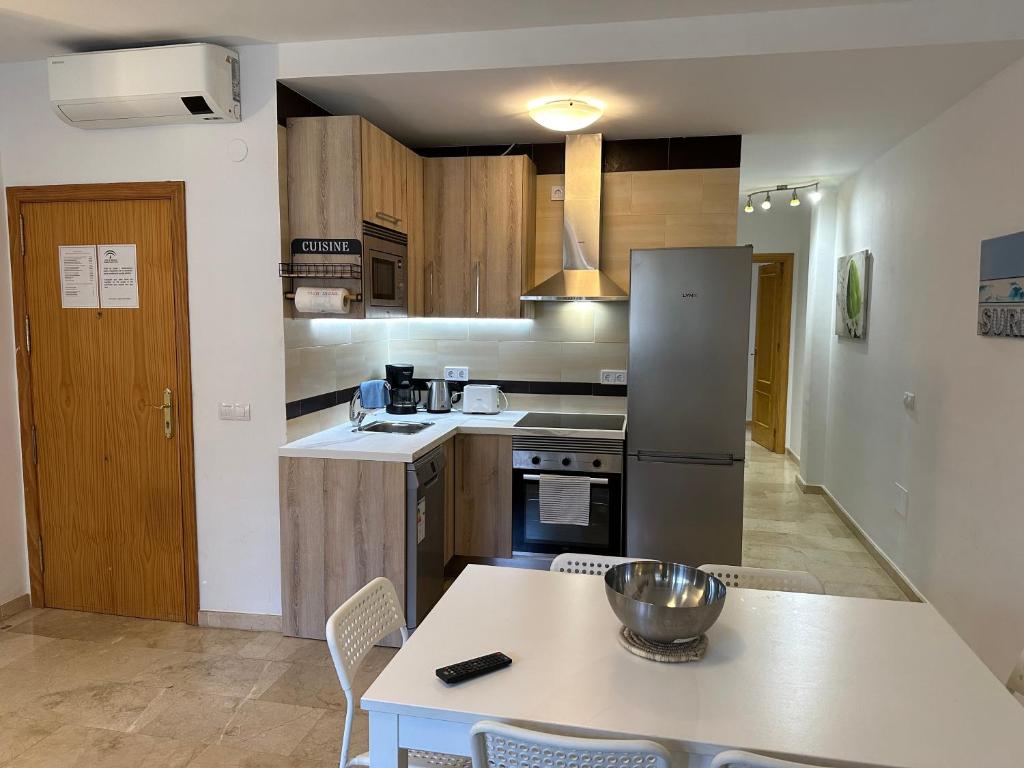 a kitchen with a table and a refrigerator at Mijas Playa Retreat in La Cala de Mijas