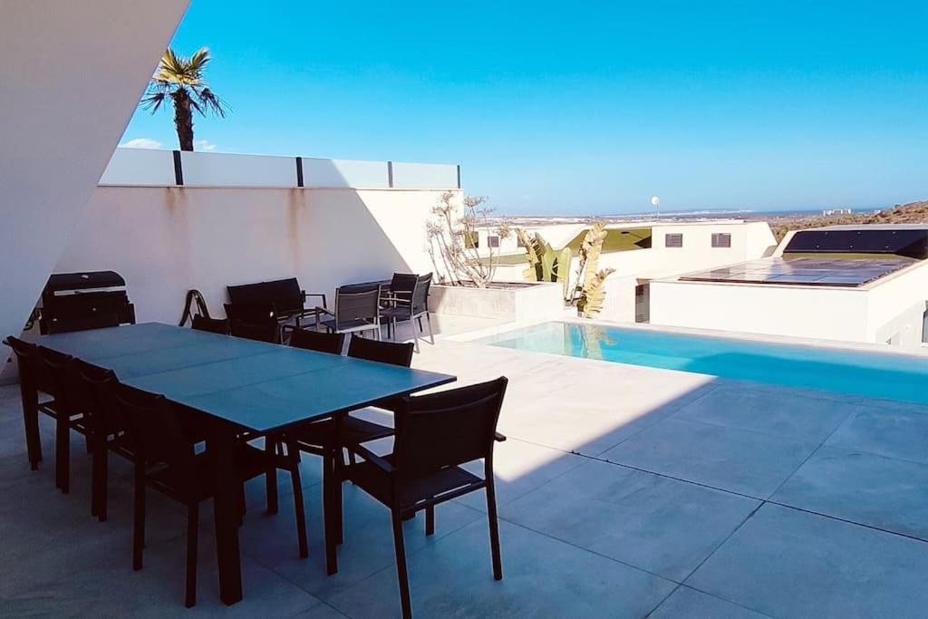 - une table et des chaises sur une terrasse à côté de la piscine dans l'établissement Luxury Bella House Quesada, à Rojales