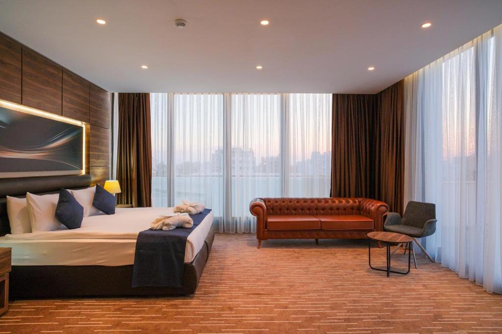 ファマグスタにあるEkor Elegance Hotelのベッドルーム1室(ベッド1台、ソファ、椅子付)