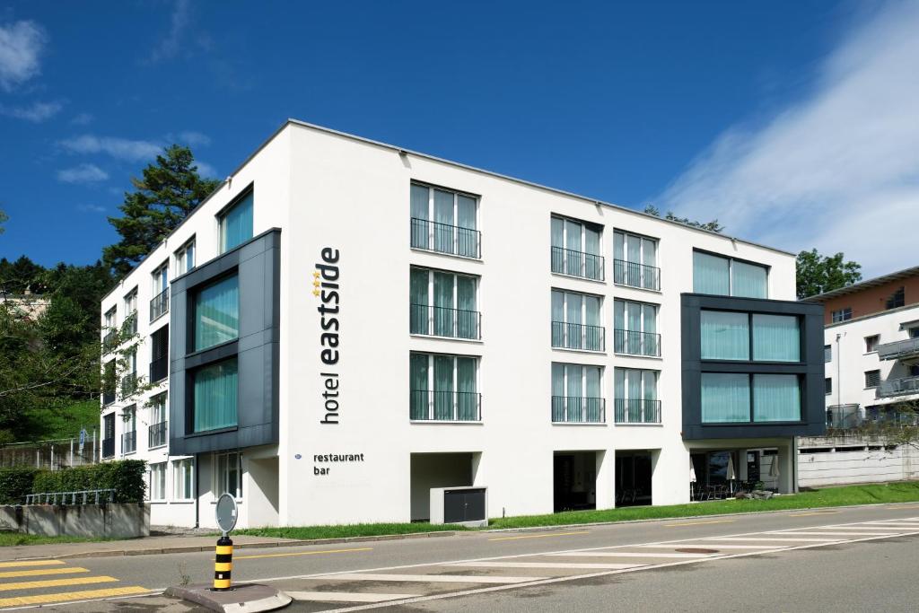 un edificio blanco con un cartel en el costado en Hotel Eastside (free parking garage) en St. Gallen