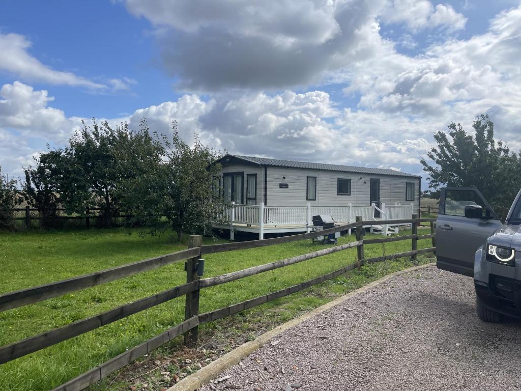 ein Mobilheim auf einem Feld neben einem Zaun in der Unterkunft Orchard View Caravan in Boston