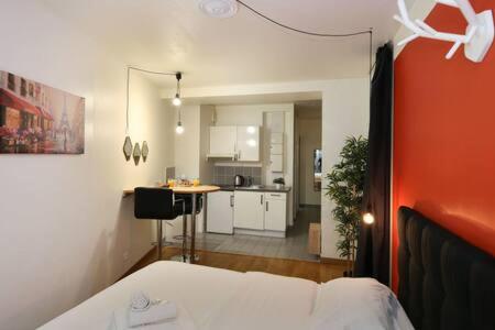 - une chambre avec un lit et une cuisine en arrière-plan dans l'établissement 101 - Studio confortable avec kitchenette Paris 5 - FLAT-GUEST, à Paris