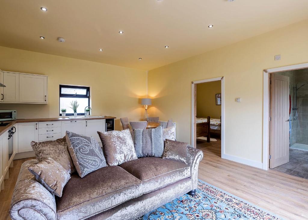 uma sala de estar com um sofá e uma cozinha em Beech Tree Lakes Lodges em Hatfield