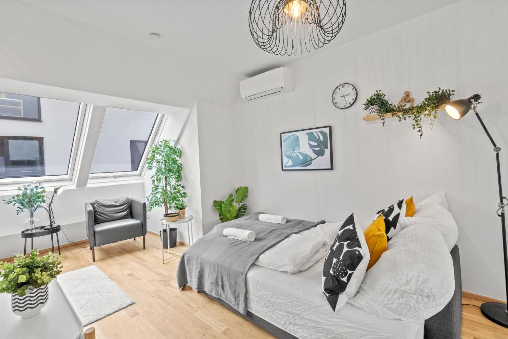 a white bedroom with a bed and a chair at Long Term Stay - Near Klinik Floridsdorf - On-Site Parking for 19,90 Eur in Vienna