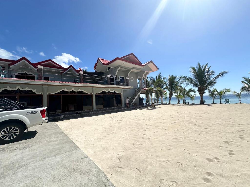 聖胡安的住宿－Lawson’s Beach Resort，停在海滩上房子前面的一辆白色卡车
