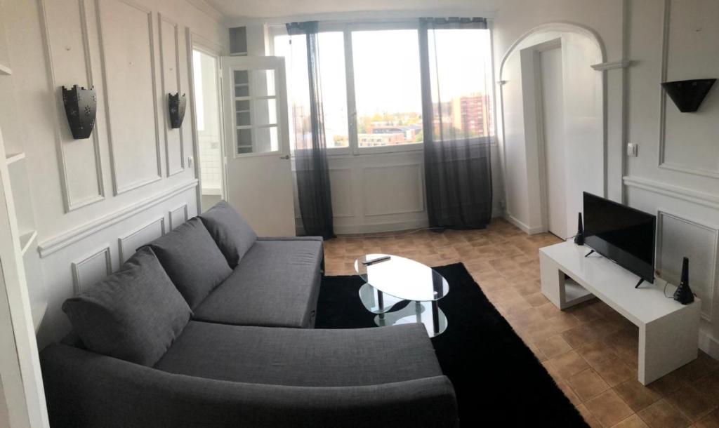 un salon avec un canapé et une télévision dans l'établissement Résidence Saint-Remy, à Saint-Denis