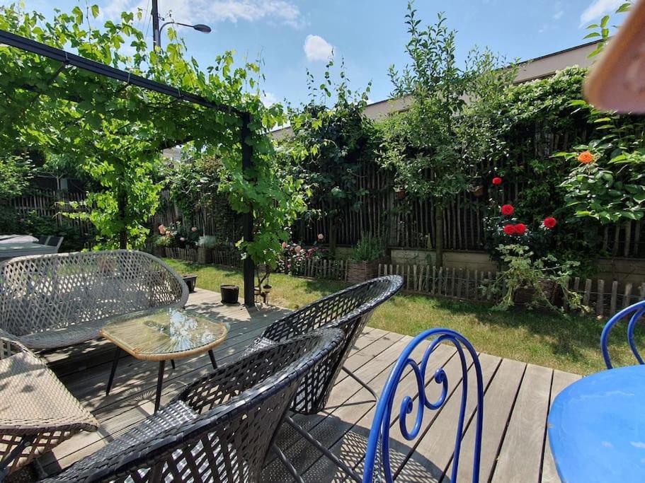 eine Terrasse mit Stühlen, einem Tisch und Stühlen in der Unterkunft Appartement dans un jardin in Genf