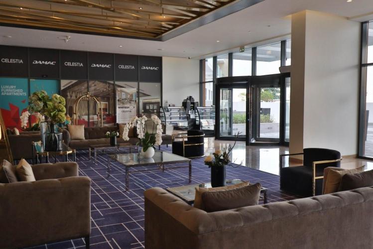hol z kanapami i stołami w budynku w obiekcie Luxury living near Dubai Expo - Dubai South - Ezytrac Vacation Homes w Dubaju