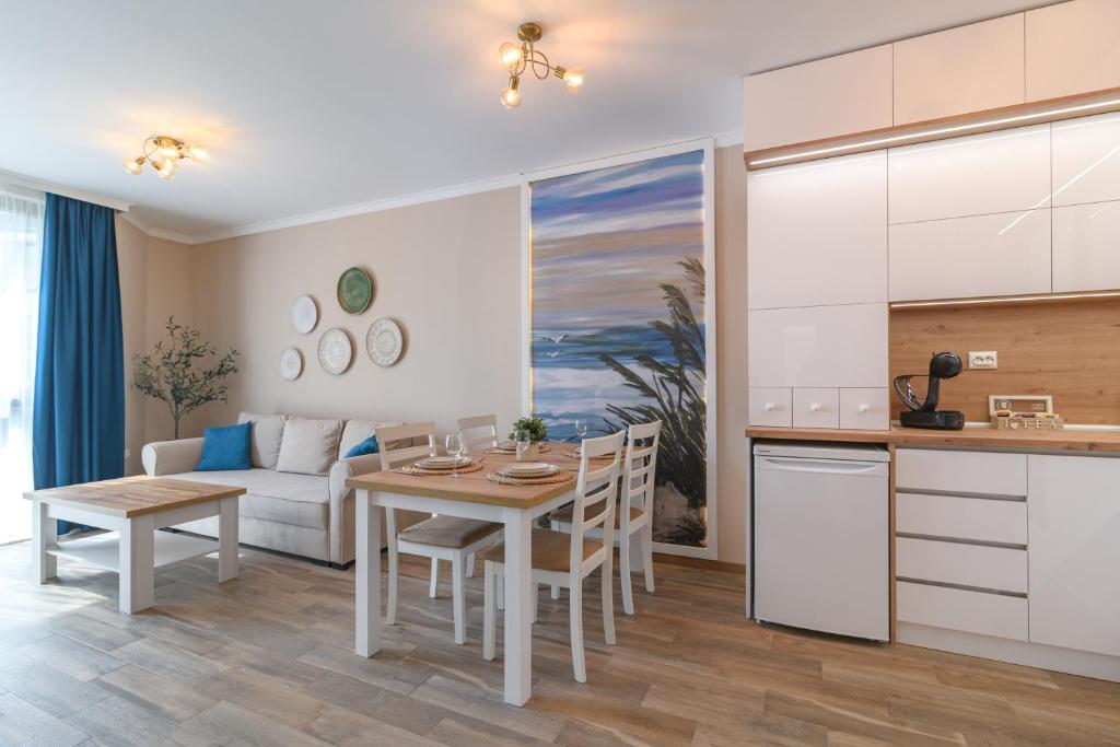 une cuisine et un salon avec une table et un canapé dans l'établissement Marine Deluxe Apartment, à Saints Constantine et Helena