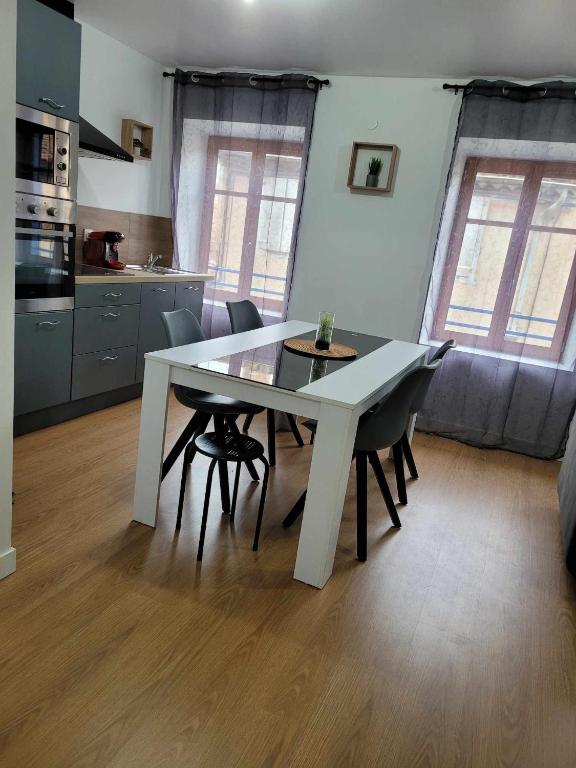 - une table à manger blanche et des chaises dans la cuisine dans l'établissement Charmant T3 avec terrasse, à Carcassonne