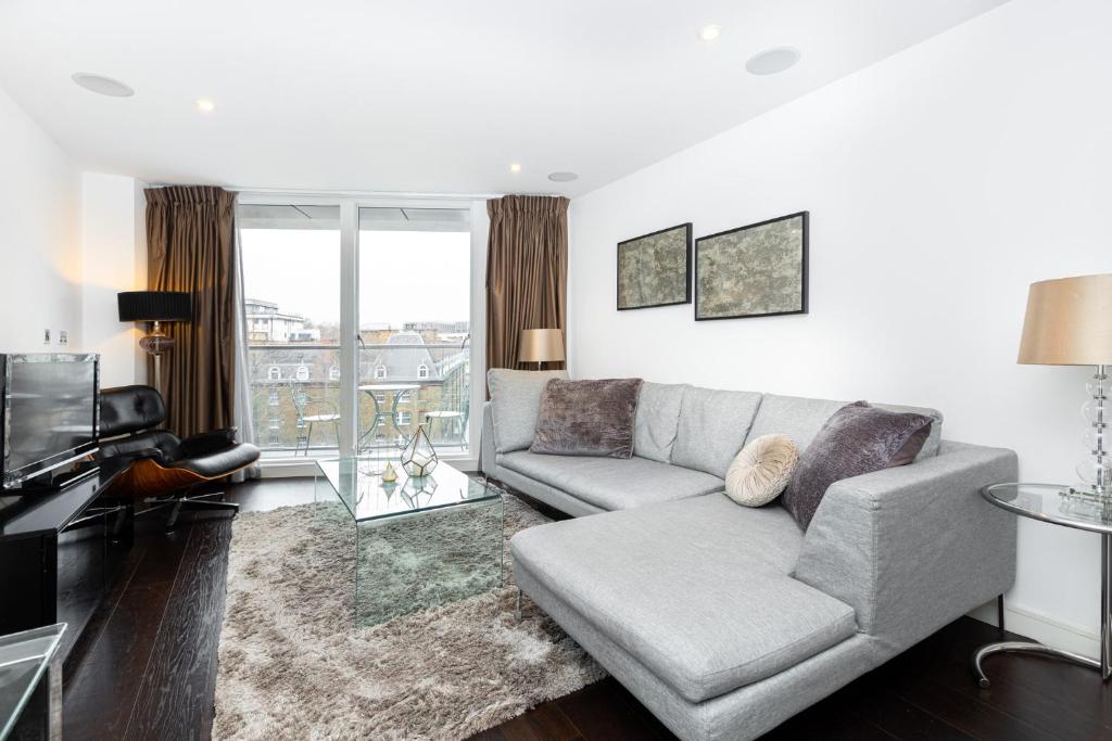 a living room with a couch and a tv at Stylish Central 2BR Flat, Belgravia, Chelsea in London