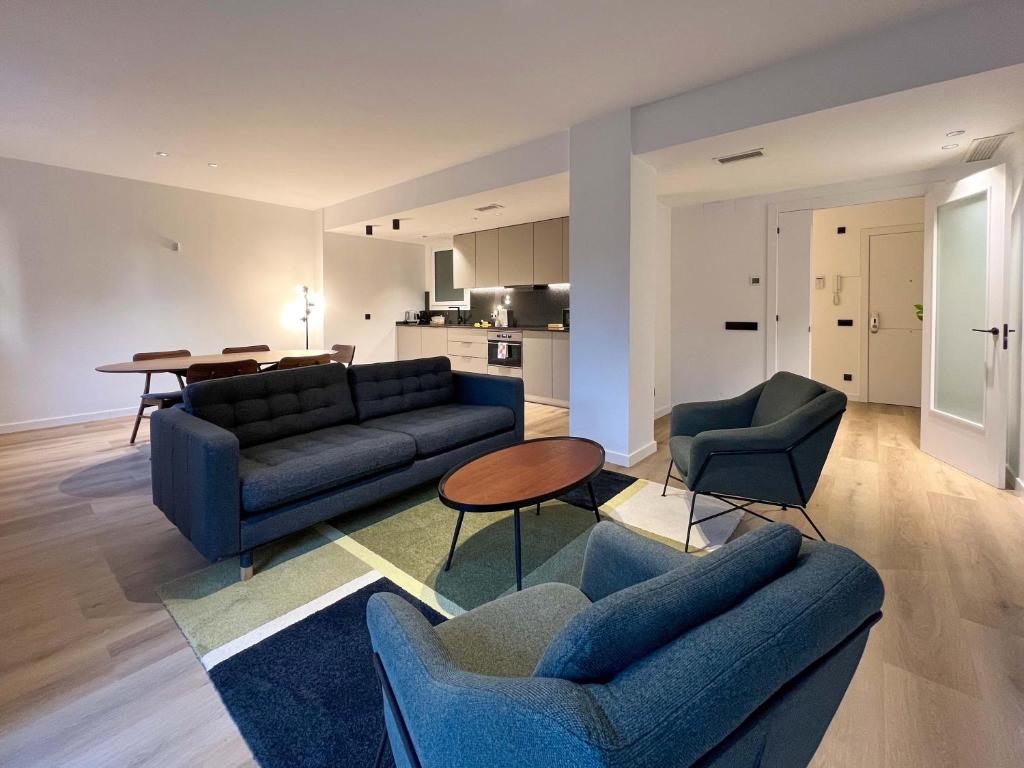 a living room with blue couches and a table at Stay U-nique Apartment Putxet in Barcelona