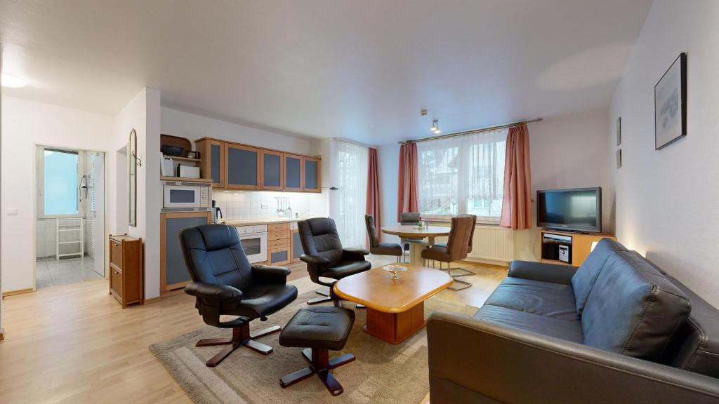 a living room with a couch and chairs and a table at strandnahe FeWo mit Schwimmbad im Haus, a cappella 63, Binz in Binz