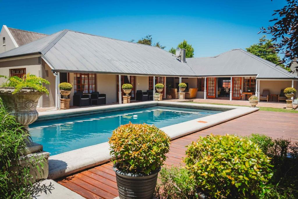 a swimming pool in front of a house at Atello Guesthouse in George