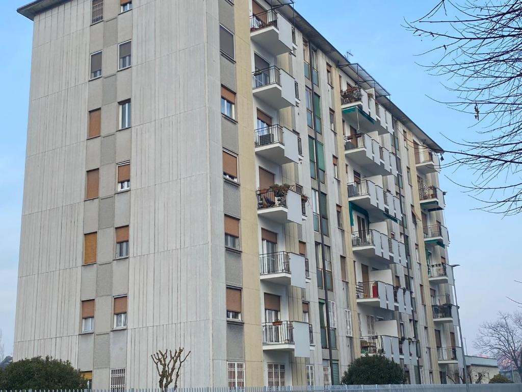 ein hohes Gebäude mit Balkon an der Seite in der Unterkunft Casa Manolo Cesano Suite Apartment Milan in Cesano Boscone