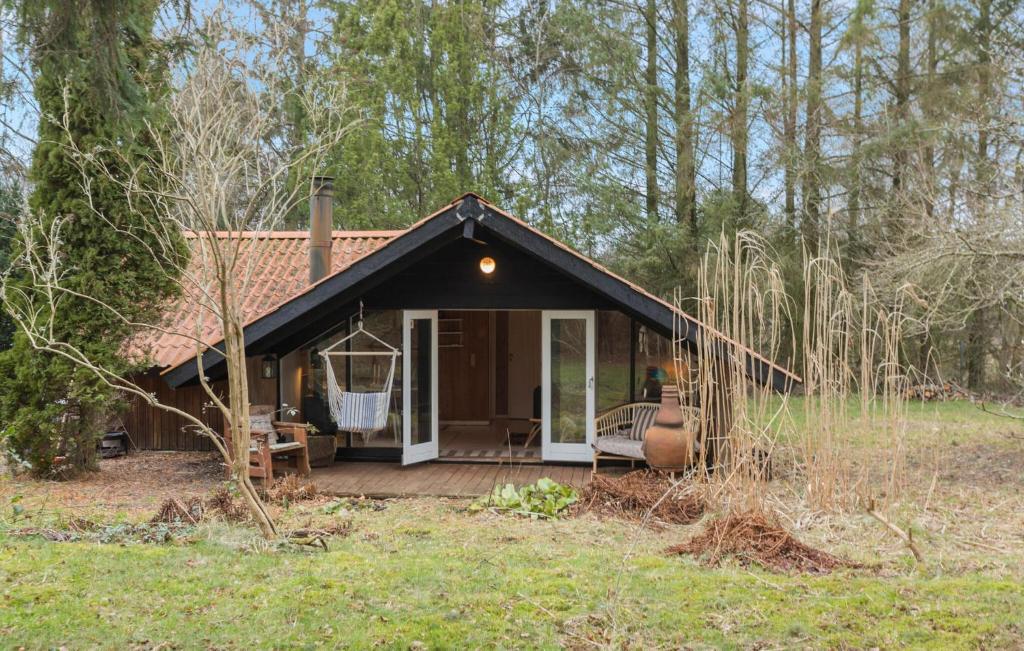 una pequeña casa con terraza en un campo en Gorgeous Home In Melby With Wifi, en Melby