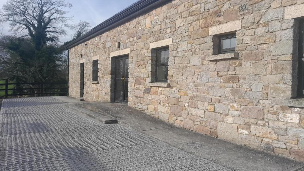 a stone building with a brick wall and a door at Rathgillen House in Nobber