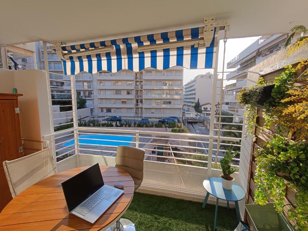 un ordinateur portable assis sur une table sur un balcon dans l'établissement Cocon d'Azur, à Cannes
