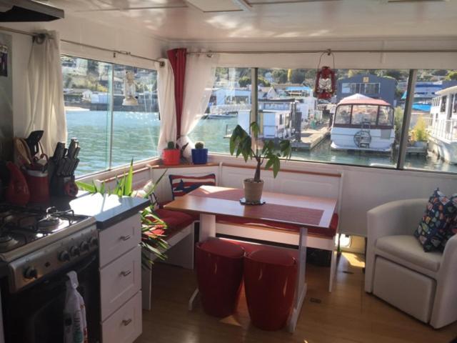a kitchen with a table and a boat in the water at Super cute, cozy houseboat in great location!!! in Sausalito