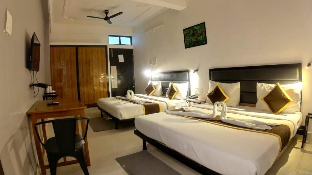 a hotel room with two beds and a desk at HOLIDAYY INN in Prayagraj