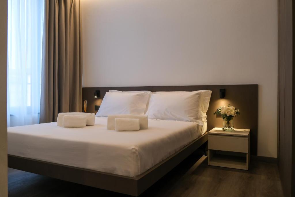 a bedroom with a large bed with white sheets and pillows at Emerald Green Residence in Caldiero