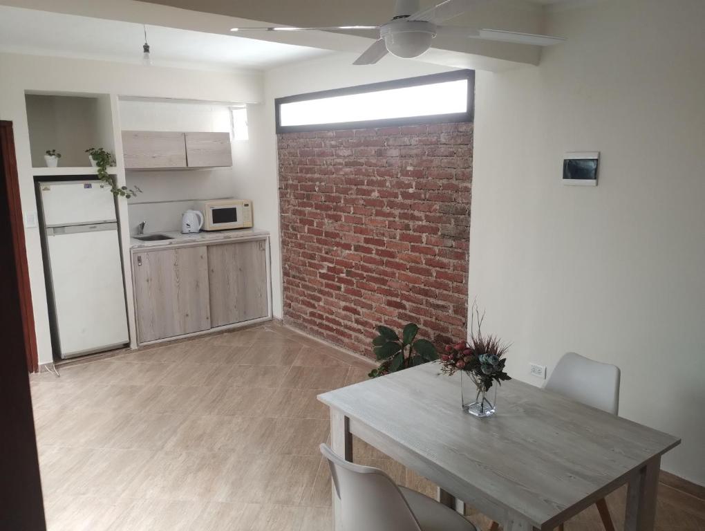 ein Wohnzimmer mit einem Tisch und einer Ziegelwand in der Unterkunft Jujuy Boutique in San Salvador de Jujuy