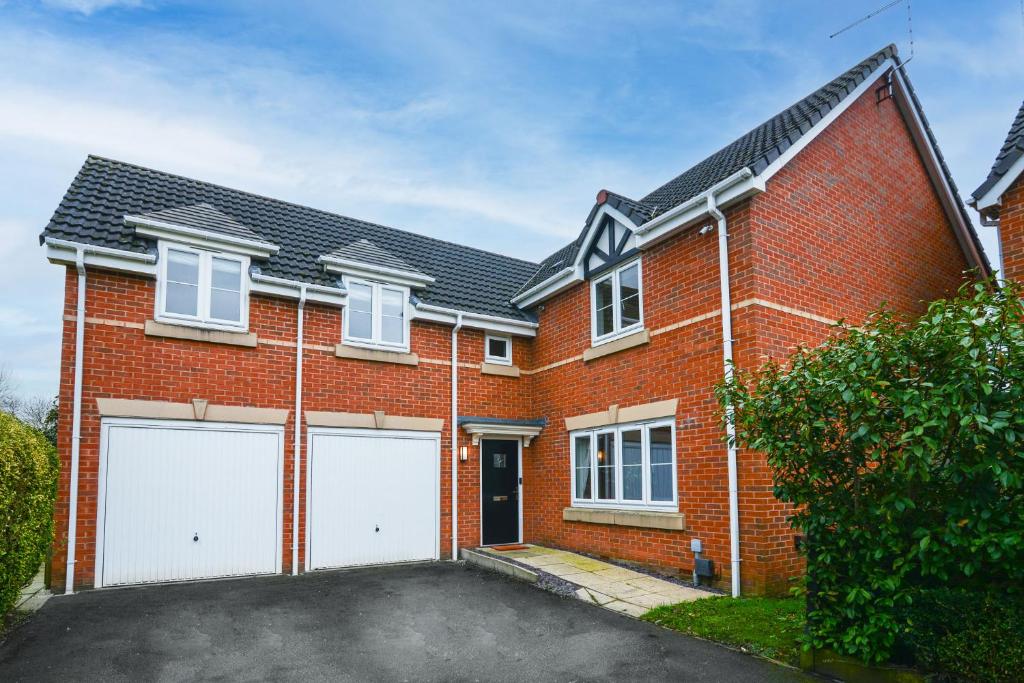 a red brick house with two white garage doors at Amazing City Centre Home in Derby